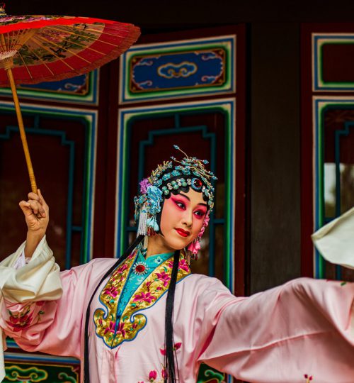 Vibrant portrait of a Chinese opera performer with intricate costume and parasol in Taiwan.